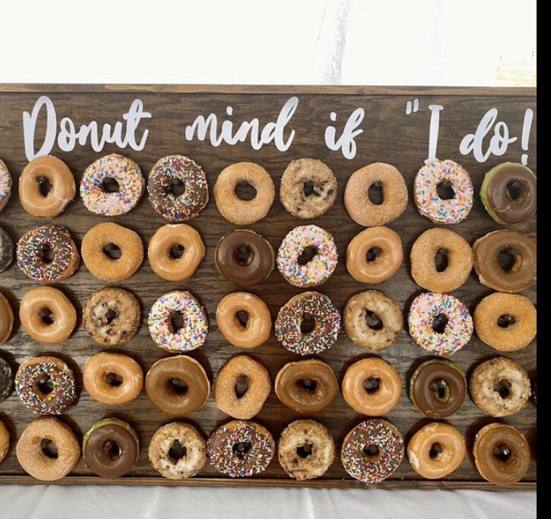 Our Donut walls are sure to be a hit at your next party or event! Each one comes with a stand on the back and has a variety of color choices. It has 30 pegs, and they can be short, that hold 1 donut per peg or long, that hold 2 donuts peg.
