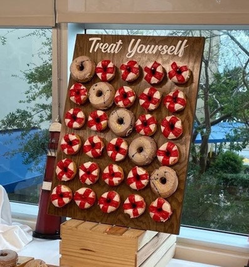 Our Donut walls are sure to be a hit at your next party or event! Each one comes with a stand on the back and has a variety of color choices. It has 30 pegs, and they can be short, that hold 1 donut per peg or long, that hold 2 donuts peg.