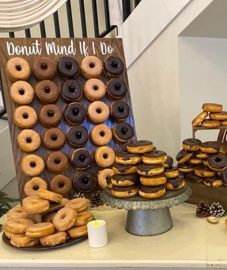 Our Donut walls are sure to be a hit at your next party or event! Each one comes with a stand on the back and has a variety of color choices. It has 30 pegs, and they can be short, that hold 1 donut per peg or long, that hold 2 donuts peg.