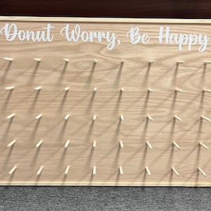 Our Donut walls are sure to be a hit at your next party or event! Each one comes with a stand on the back and has a variety of color choices. It has 30 pegs, and they can be short, that hold 1 donut per peg or long, that hold 2 donuts peg.