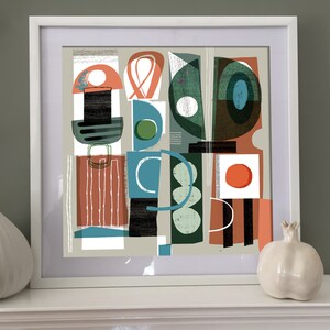 May include: Abstract art print featuring geometric shapes in shades of green, blue, red, and white. The print is framed in a white frame.