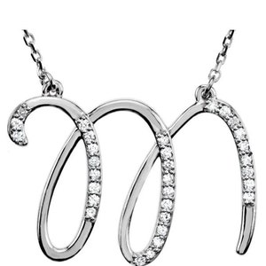 May include: A silver necklace with a cursive letter M pendant encrusted with small diamonds.