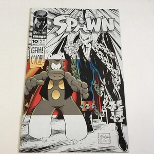 May include: A Spawn comic book issue 10 from May, featuring a black and white cover with a central character in chains and a smaller cartoon-style creature in the foreground. The text reads Spawn, Image, 10, May, $1.95, $2.45 Canada, and GAH! COLOR!
