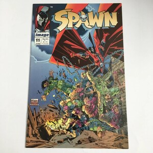 May include: A Spawn comic book issue 11, published by Image, featuring a dynamic cover illustration of the character Spawn in a red cape and chains, hovering above a chaotic battle scene with multiple figures in a debris-filled urban environment.