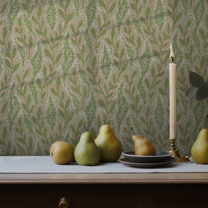 May include: A still life composition with pears in shades of yellow and green on a table. A lit candle in a brass holder and a vase with foliage are also present. The backdrop is wallpaper with a green and beige leaf pattern. The table is made of dark wood.