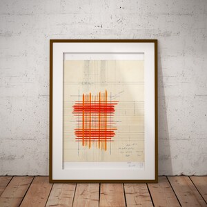 May include: A framed abstract art print featuring a red and orange grid pattern on a beige background. The print includes handwritten text in the bottom right corner.