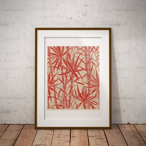 May include: A framed print of a red and white botanical illustration of palm leaves and bamboo stalks. The print is on a beige background and has a white mat.