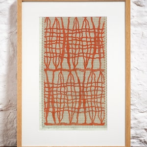 May include: A framed print featuring a repeating geometric pattern of vertical and horizontal orange lines over a light gray grid background. The artwork is enclosed in a light-colored wooden frame with a white mat border, displaying a structured design.