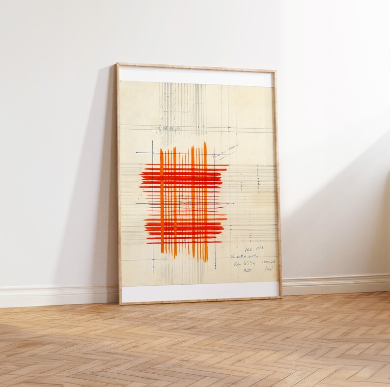 May include: A framed abstract art print with a red and orange grid pattern on a beige background. The print has a grid pattern and handwritten text in the bottom right corner.