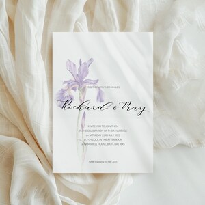 May include: A wedding invitation featuring a watercolor illustration of a purple iris flower. The invitation includes the names "Richard & Ray" in elegant script, along with event details. The background is a soft, off-white color.