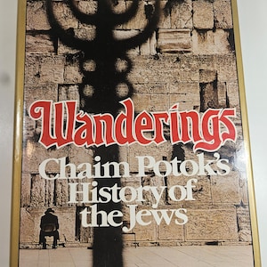 May include: A book cover with the title "Wanderings" in red lettering. The cover features a shadow of a menorah and the text "Chaim Potok's History of the Jews". A person is seated in the lower left corner.