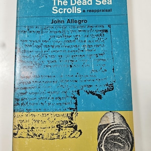 May include: A white ceramic mug with a black handle and the text "But First, Coffee" in a bold, black font. The mug is set against a blurred background, suggesting a cozy setting. The mug appears to be approximately 4 inches tall.