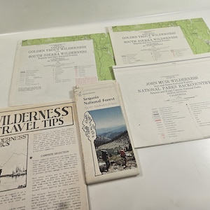 May include: A collection of vintage wilderness maps and travel guides. The maps feature the Golden Trout Wilderness and John Muir Wilderness areas. A brochure for Sequoia National Forest is also included, along with a guide titled "Wilderness Travel Tips."