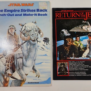 May include: Two Star Wars books. The first book is a punch-out and make-it book for "The Empire Strikes Back". The cover features Luke Skywalker riding a Tauntaun. The second book is a movie tie-in for "Return of the Jedi". The cover features the main characters from the movie.