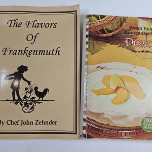 May include: Two spiral bound cookbooks. The cookbook on the left is titled "The Flavors of Frankenmuth" with a silhouette of a girl and a rooster. The cookbook on the right is titled "Favorite Recipes of Episcopal Churchwomen Desserts" with a photo of a peach dessert on the cover.