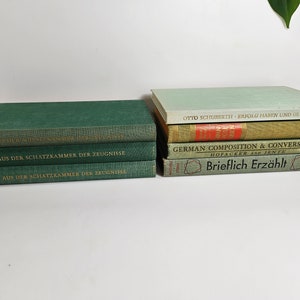 May include: A stack of vintage green hardcover books with gold lettering titled "Aus der Schatzkammer der Zeugnisse" and a stack of vintage green and beige hardcover books with titles including "Otto Schuberth Erfolg Haben und Glücklich Sein", "German Composition & Conversation", and "Brieflich Erzählt".