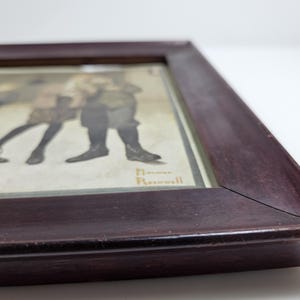 May include: A framed print of a vintage illustration depicting four children in a line, wearing winter clothing. The illustration is signed "Norman Rockwell".