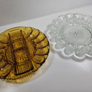 May include: Two glass serving dishes, one amber and one clear, both with a scalloped edge and a design of small, raised dots. The amber dish has a central divider for serving multiple items.