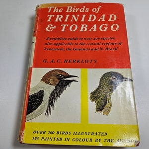 May include: A red, yellow, and white book cover with the title "The Birds of Trinidad & Tobago". The cover features illustrations of two birds, one black and white and the other green. The text "Over 260 Birds Illustrated 195 Painted in Colour by the Artist" is at the bottom of the cover.