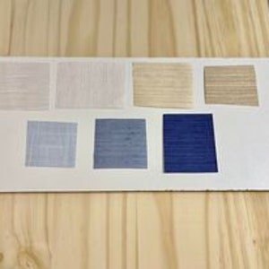 May include: Swatch card with eight fabric samples in various shades of white, beige, blue, and gray. The samples are arranged in two rows of four.