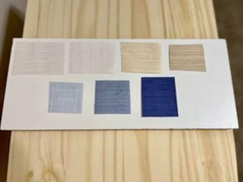 May include: Swatch card with eight fabric samples in various shades of white, beige, blue, and gray. The samples are arranged in two rows of four.