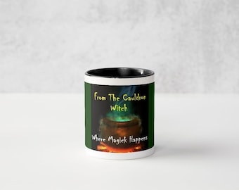 Puede incluir: Taza de cerámica blanca con interior y borde negros. La taza presenta un diseño con un caldero, humo verde y el texto "From The Cauldron Witch Where Magick Happens."