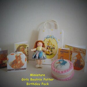 May include: A miniature birthday set featuring a small doll with red hair in a patterned dress, a white gift bag with a rabbit illustration, a round pink and white cake, and several small greeting cards with vintage-style character graphics.