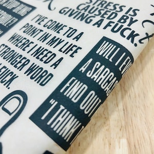 May include: A white tote bag with black text that reads "Stress is caused by giving a fuck. Will I ever find out? I think I'm a sarcastic...