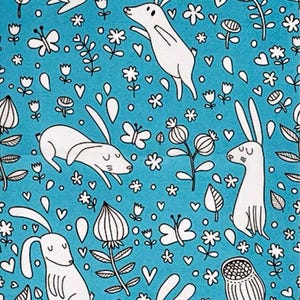 May include: A teal fabric featuring a repeating pattern of white rabbits, flowers, butterflies, and hearts. The design is a whimsical illustration style, with black outlines. The overall theme is spring or nature-inspired.