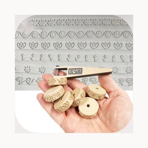 May include: A beige pottery tool with the brand name Pott'r printed on the handle, featuring a set of interchangeable cylindrical rollers with various embossed floral and geometric patterns for clay texturing and surface decoration.