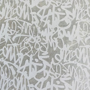 May include: Abstract pattern of white graffiti on a grey background. The graffiti is in a variety of styles and sizes, creating a dynamic and energetic design.