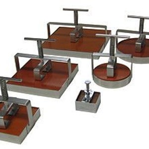 May include: Set of six stainless steel cookie cutters with wooden handles. The cutters are in various shapes, including square, round, and rectangular.
