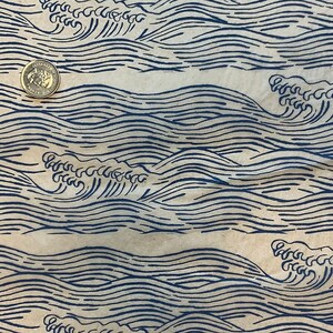 May include: A brown paper bag with a blue and white wave pattern printed on it. The pattern is repeated across the bag.