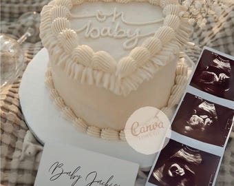 May include: A heart-shaped cake with cream frosting and the words "oh baby" in cursive. A card reads "Baby Jackson arriving 2026" next to ultrasound images. The cake is on a white plate, with flowers.