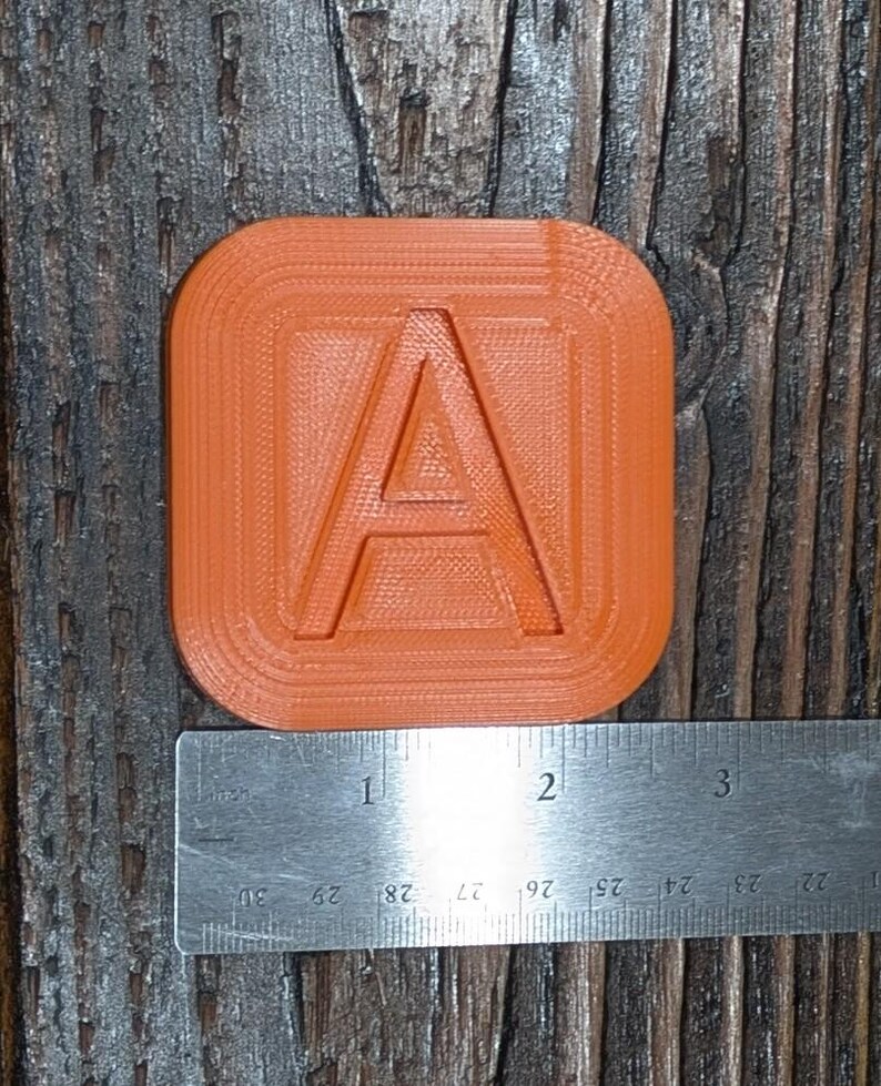 May include: Orange plastic letter A with a raised, textured surface. The letter is approximately 2 inches wide.