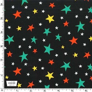 May include: A black fabric featuring a repeating pattern of five-pointed stars in teal, orange, yellow, and white. A white ruler along the left and bottom edges shows measurements in inches, with a Michael Miller Fabrics logo in the bottom corner.