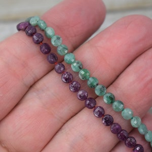 May include: Two strands of gemstone beads, one strand of green faceted beads and one strand of purple faceted beads.