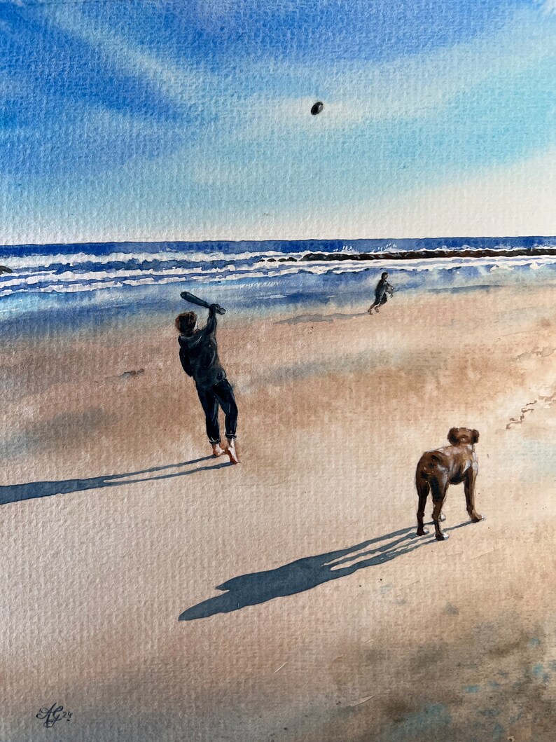 May include: A watercolor painting of a person swinging a bat at a ball on a beach with a dog standing nearby. The sky is blue and the water is a light blue. The sand is a light brown.