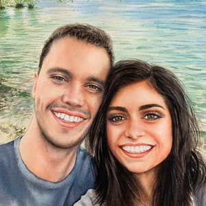 May include: A watercolour painting of a couple smiling at the camera. The man is wearing a blue shirt and the woman is wearing a white shirt with a silver necklace. They are standing in front of a body of water with trees in the background.