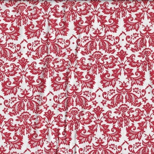 Könnte beinhalten: Roter und weißer Damaststoff mit einem sich wiederholenden Muster. Der Stoff ist in der Mitte gefaltet und ein Maßband ist rechts im Bild zu sehen.