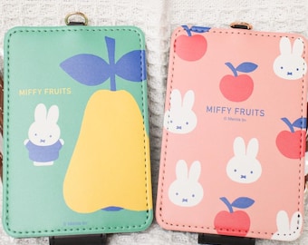 May include: Two rectangular cardholders with the text "Miffy Fruits". One is mint green with a pear and bunny illustration. The other is pink with apple and bunny illustrations. Both have a brown strap.