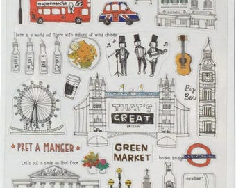 Op de afbeelding: Een vel met stickers met Londen-thema's, met iconische bezienswaardigheden zoals de Big Ben, Tower Bridge en rode telefooncellen. Bevat illustraties van een dubbeldekkerbus, een gitaar en de tekst "That's Great Britain."