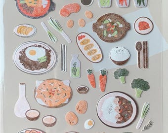 May include: A sheet of Suatelier stickers with food illustrations. The stickers depict dishes such as ramen, eggs, rice, sushi, and vegetables. The text "suatelier stickers no.1091 : food trip #2" is printed on the sheet.