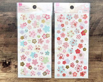 May include: Two sticker sheets featuring floral designs in various colors, including pink, blue, and gold. The stickers have different patterns and shapes, with the text "Flowers in Season" at the top.