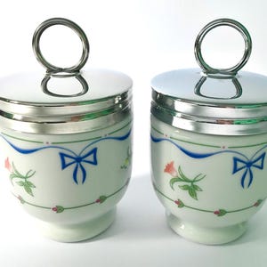 Par äggkoppar i porslin från Royal Worcester, 2 koppar i band och rosetter, två koppar i standardstorlek