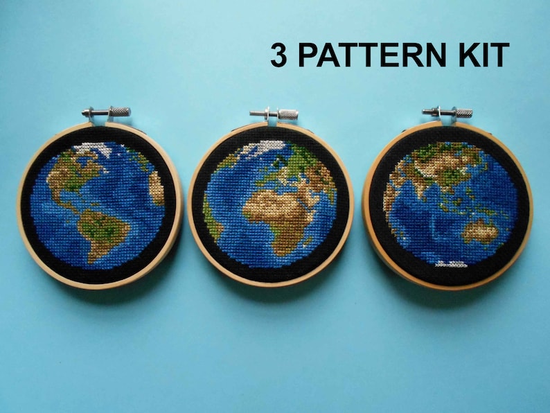 K&ouml;nnte beinhalten: Drei Stickrahmen mit Kreuzstichmustern der Erde in verschiedenen Farbvarianten. Die Rahmen sind aus Holz und haben einen schwarzen Hintergrund. Der Text "3 PATTERN KIT" ist &uuml;ber den Rahmen gedruckt.