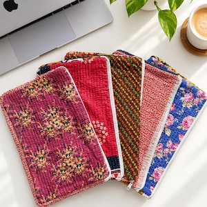 Pode incluir: Uma coleção de cinco bolsas retangulares de tecido com vários padrões acolchoados e cores, incluindo magenta com motivos florais amarelos, vermelho sólido com detalhes geométricos brancos, castanho com padrão de grelha, vermelho com estampados florais brancos e azul com rosas cor-de-rosa.