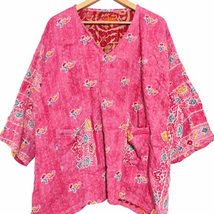 Puede incluir: Una chaqueta rosa brillante con cuello en V, textura acolchada con puntadas blancas y un patrón abstracto multicolor. La prenda incluye dos bolsillos delanteros, mangas tres cuartos y un forro interior de color rojo con motivos florales.