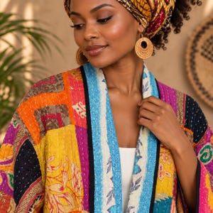 May include: A quilted jacket featuring a vibrant patchwork of floral and geometric patterns in shades of yellow, orange, pink, blue, and black. The garment has a long-sleeve open front design with a contrasting blue and white patterned trim.