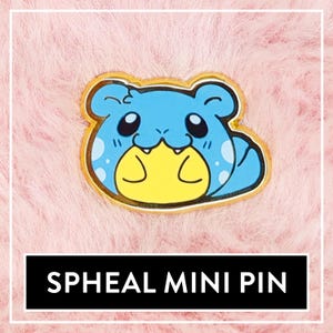 May include: A blue and yellow Spheal mini pin with a gold outline. The pin is on a pink fuzzy background.